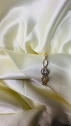 Delicate bracelet with a blue gemstone on a soft fabric background